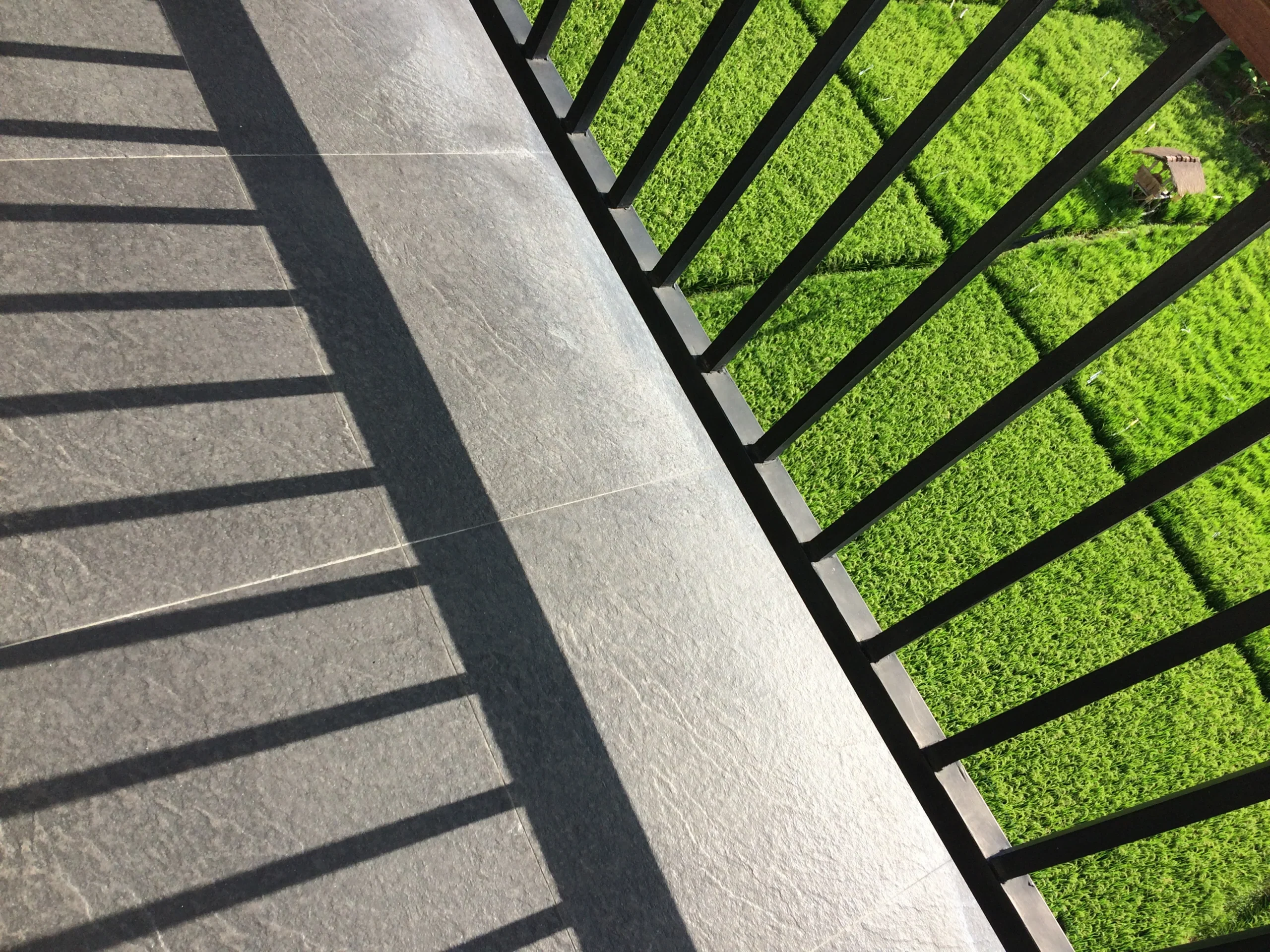 Detail balkonové terasové keramické dlažby u zábradlí v moderním exteriéru